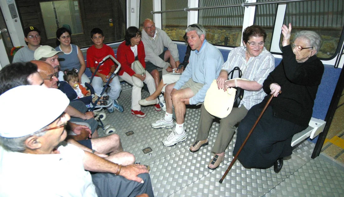 Viajeros compartiendo los asientos del funicular