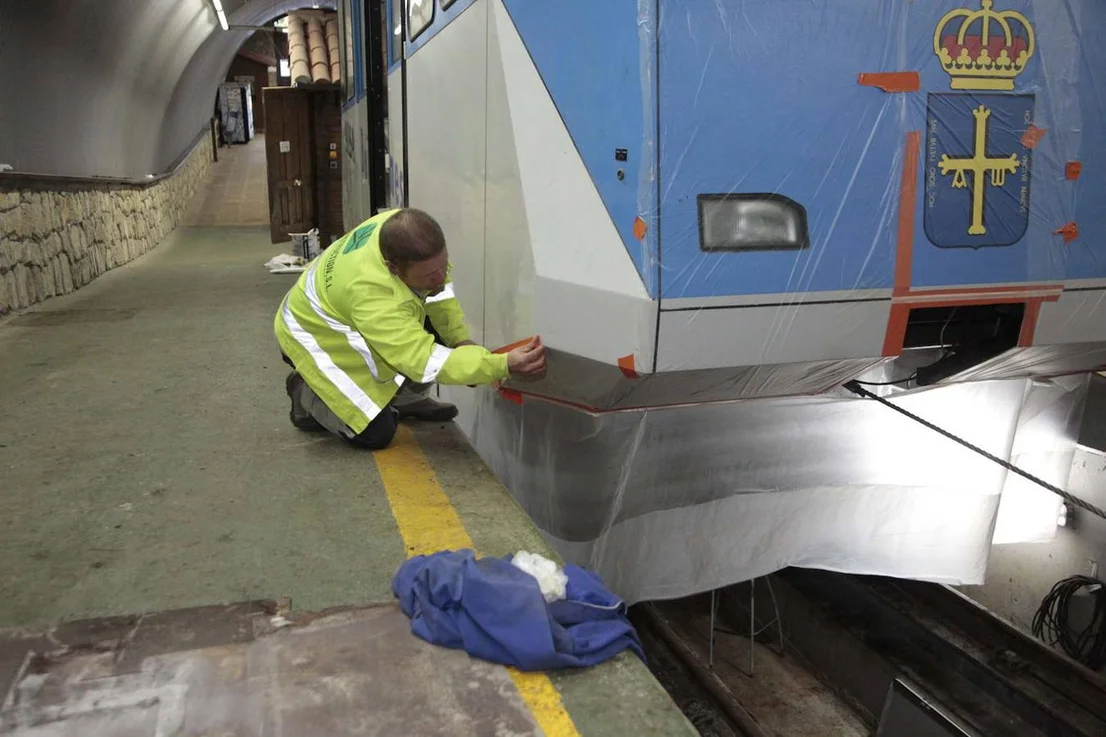 Una persona trabajando junto a la carrocería del funicular