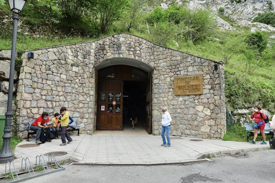 Viajeros ante la entrada de piedra de la estación