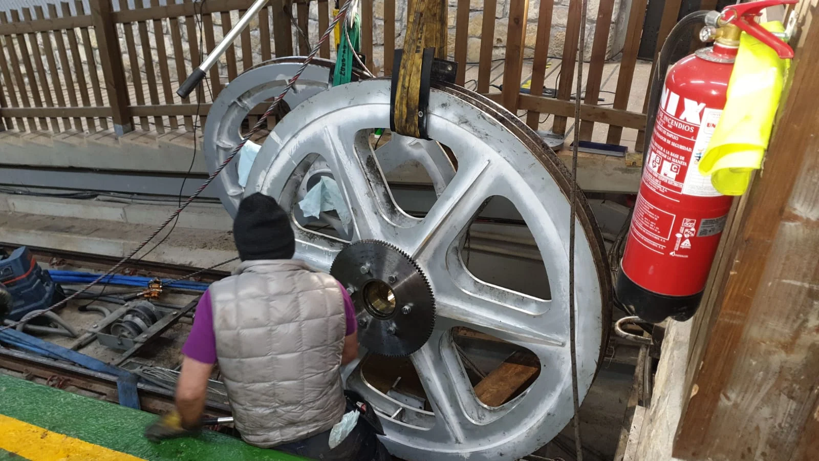 Operario trabajando junto a una polea del funicular